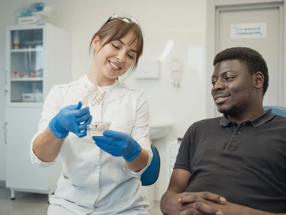 Médica dentista a explicar o tratamento a um paciente