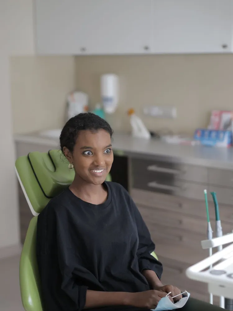 Paciente sorridente sentada na cadeira de tratamento