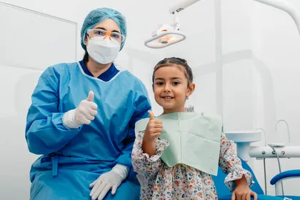 Criança sorridente com a médica dentista